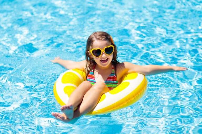 A child in a swimming pool on an inflatable yellow ring